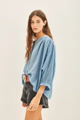 Camisa amarilla de algodón con corte amplio, cuello redondo y mangas 3/4 con puños elásticos.