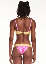 Traje de baño de dos piezas, marca Blueman. El corpiño es de corte triangular con estampado tie dye en tonos rojo y negro, con tirantes finos. La bombacha es tipo colaless con estampado tie dye en tonos rojo y negro, con tirantes finos.