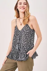 Top negro con estampado floral blanco, breteles finos y escote en V.