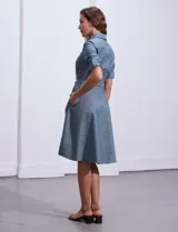 Vestido camisero blanco de algodón con cuello con solapa, delantera abotonada, mangas 3/4 regulables con presilla y botón, y cintura con lazo de ajuste.