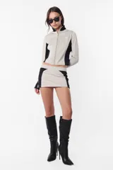 Campera deportiva negra con recortes grises en mangas y laterales. Cierre frontal y calce slim fit. Estampa de logo a tono en el recorte delantero.