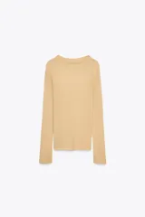 Top color beige de punto fino, con cuello barco y manga larga.