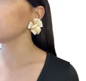 Caravanas cortas de resina con forma de flores en tonos salmón y detalle brillante.