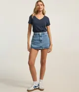 Blusa blanca de algodón con cuello en V, manga corta y bolsillo frontal.