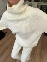 Conjunto de sweater y pantalón de punto color crema con diseño trenzado.