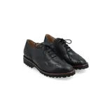 Zapato Oxford color bronce con detalles de perforaciones y suela blanca de goma.