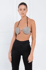Top plateado con apliques circulares y tiras finas negras.
