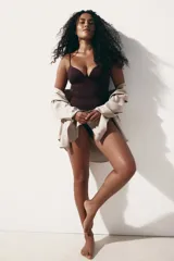 Body color borgoña con breteles finos regulables, escote en V, copas push-up sin aro y refuerzo interior con botones a presión ocultos. Diseño colaless y sin costuras con efecto moldeador en cintura y caderas.
