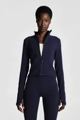 Campera deportiva corta color azul marino, de corte ajustado, cuello alto y cierre frontal. Confeccionada en tejido funcional SoftMove™ y DryMove™, mangas largas con abertura para el pulgar.