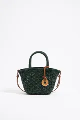 Bolso tejido color verde oscuro con asas cortas y correa marrón.