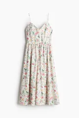 Vestido midi blanco con estampado de flores rosas y amarillas, breteles finos y escote en V.