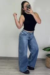 Pantalón jean celeste de tiro medio, corte ancho y estilo baggy.