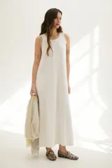 Vestido largo azul con cuello redondo y sisas con ribete color beige.