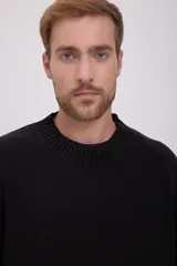 Sweater negro de punto con cuello redondo y mangas largas.