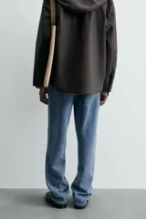 Pantalón de jean celeste, de corte recto desde la cadera hasta el tobillo, con tiro medio, cinco bolsillos y cierre frontal con botón.