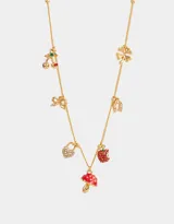 Collar corto dorado con cadena de eslabones y dijes colgantes: cerezas, moño, trébol de cuatro hojas, herradura, candado de corazón, manzana mordida y hongo rojo con lunares blancos.
