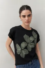 Remera negra de manga corta con estampado de flores en el frente y calce relajado.
