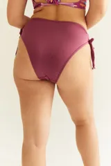 Bikini de tiro alto color burdeos, con tiras regulables en los costados.