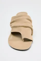 Sandalia tipo mule color beige, de ante, con tacón fino medio y tira ancha con efecto arrugado.