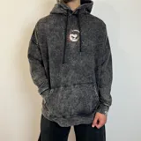 Canguro negro con efecto gastado, corte oversize, capucha con cordones ajustables y bolsillo tipo canguro. Estampa en el pecho con un personaje de caricatura y texto.