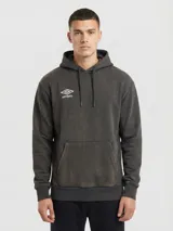 Buzo canguro de felpa con capucha y bolsillo canguro frontal. Color gris oscuro con efecto lavado o gastado, y logo Umbro en blanco en el pecho.