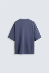 Camiseta azul de corte holgado, cuello redondo y manga corta. Tiene un efecto lavado que le da una apariencia única.