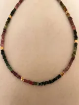 Gargantilla de piedras irregulares de turmalina multicolor con detalles de cuentas doradas.