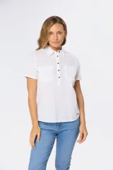 Camisa color beige de lino y algodón, de manga corta, con cuello clásico, medio abotonado y dos bolsillos en el pecho.