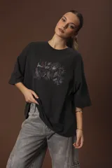 Remera negra de corte oversize con estampado abstracto en tonos rojos, grises y blancos.