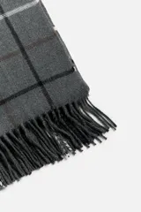 Bufanda gris con diseño a cuadros en blanco, negro y marrón. Terminaciones con flecos.