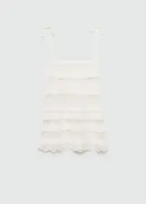 Top de punto fino color crema, con tirantes finos con cierre de lazo, escote cuadrado, diseño calado y terminaciones en contraste.