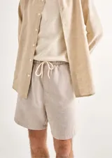 Bermuda verde de tela texturizada con cintura elastizada y cordón de ajuste.