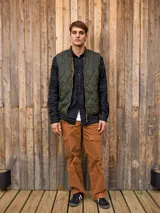 Chaleco acolchado verde militar sin mangas, con cuello tipo baseball y cierre de cremallera.