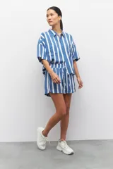 Short pijama con rayas verticales azules y blancas, con elástico en la cintura y cordones ajustables.