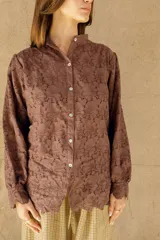 Camisa marrón con bordado calado, cuello mao y cierre frontal con botones.
