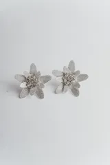Par de aros plateados con forma de flor y centro con apliques brillantes.
