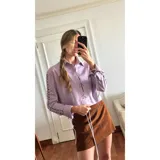 Camisa lila de cuero ovino desgastado, con cutouts en las mangas y cierre frontal con botones.