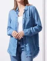 Camisa de jean celeste con flecos en el ruedo, de mangas largas y corte recto.