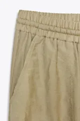 Pantalón jogger marrón de tiro alto con cintura elástica ajustable con cordones, bolsillos delanteros y puños elásticos en los tobillos.