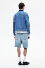 Bermuda de denim celeste, de corte recto y largo hasta la rodilla.