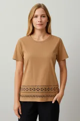 Remera color beige con cuello redondo y estampado con motivos geométricos en el ruedo.