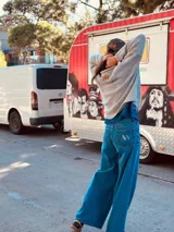 Pantalón de jean ancho de color azul, con bordado de las iniciales AW en el bolsillo trasero.