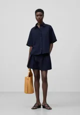 Bermuda corta azul marino de seersucker de algodón con volumen amplio, cintura elástica con cordón, bolsillos laterales y bolsillo de vivo en la espalda.