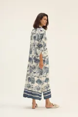 Vestido camisero largo de seda color blanco con estampado de serpientes, árboles y animales en azul.