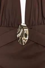Vestido midi marrón de cuello halter confeccionado en hilatura con mezcla de poliamida. Espalda descubierta, detalle de aplicación metálica en delantero y drapeado lateral.