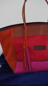 Bolso de fin de semana tipo tote bag, confeccionado en lona y gamuza, con detalles en cuero color marrón. Tiene un bolsillo interno con cierre.