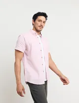 Camisa azul de manga corta, con cuello abotonado y bolsillo en el pecho.