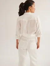 Camisa color marrón de lino y viscosa, de corte clásico, con cuello camisero, cierre frontal con botones, mangas largas con puños abotonados y dos bolsillos de parche en el pecho.