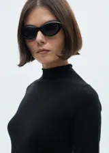 Vestido midi negro de tejido de punto fino, con cuello alto, manga larga, corte ajustado y abertura lateral en el ruedo.