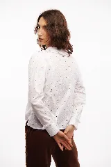 Camisa blanca de broderie de algodón, con cuello y mangas con volados.